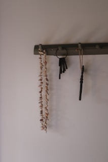 Necklace, keys, and other items hanging on a rack.