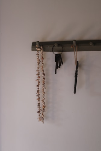 Necklace, keys, and other items hanging on a rack.