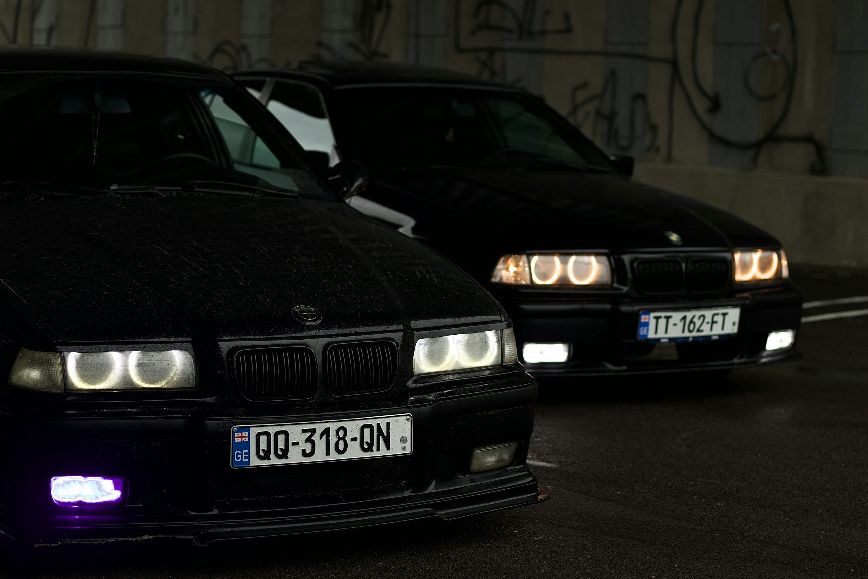 Two black BMW cars are parked.