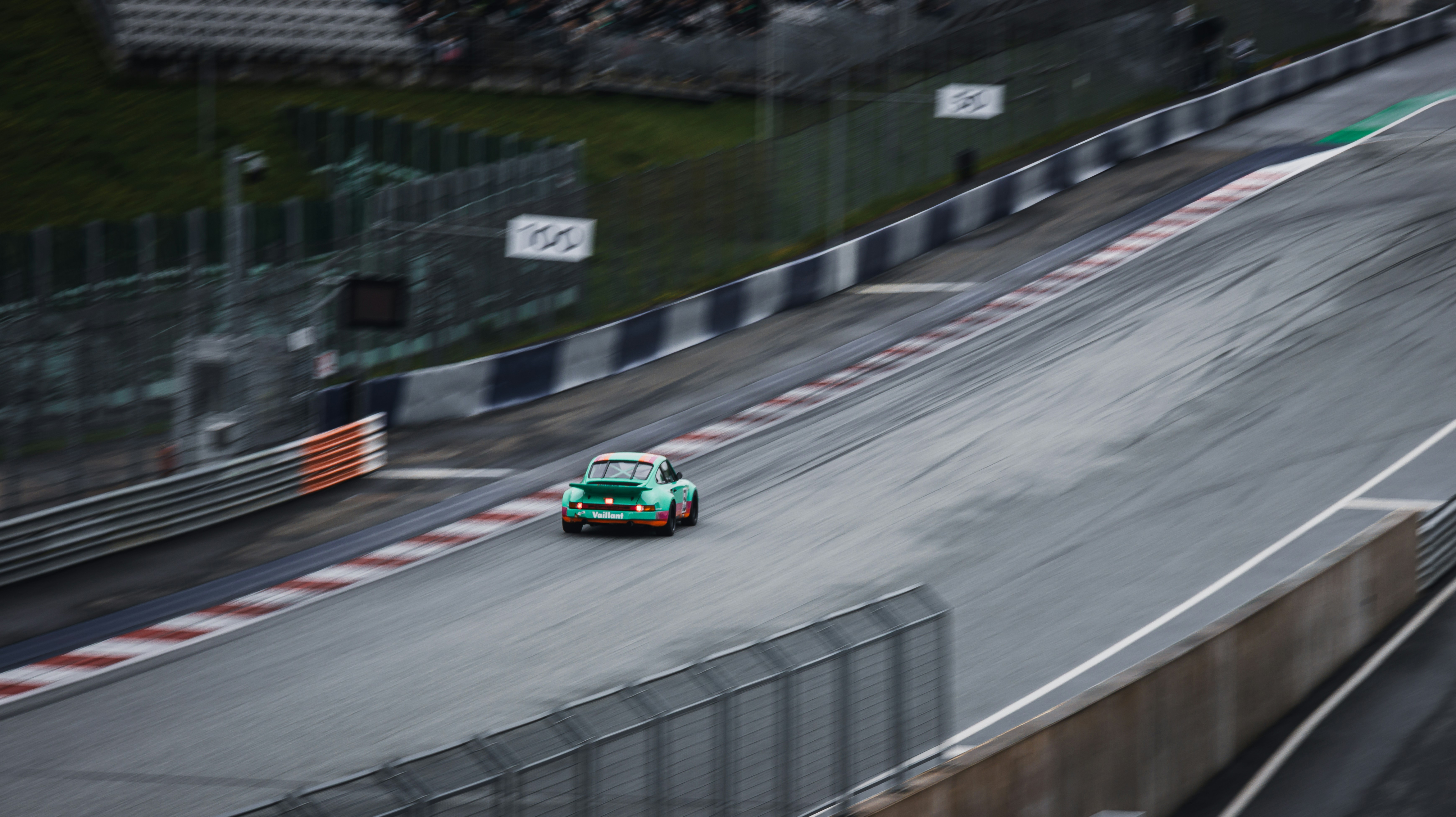 A green car races on the racetrack.
