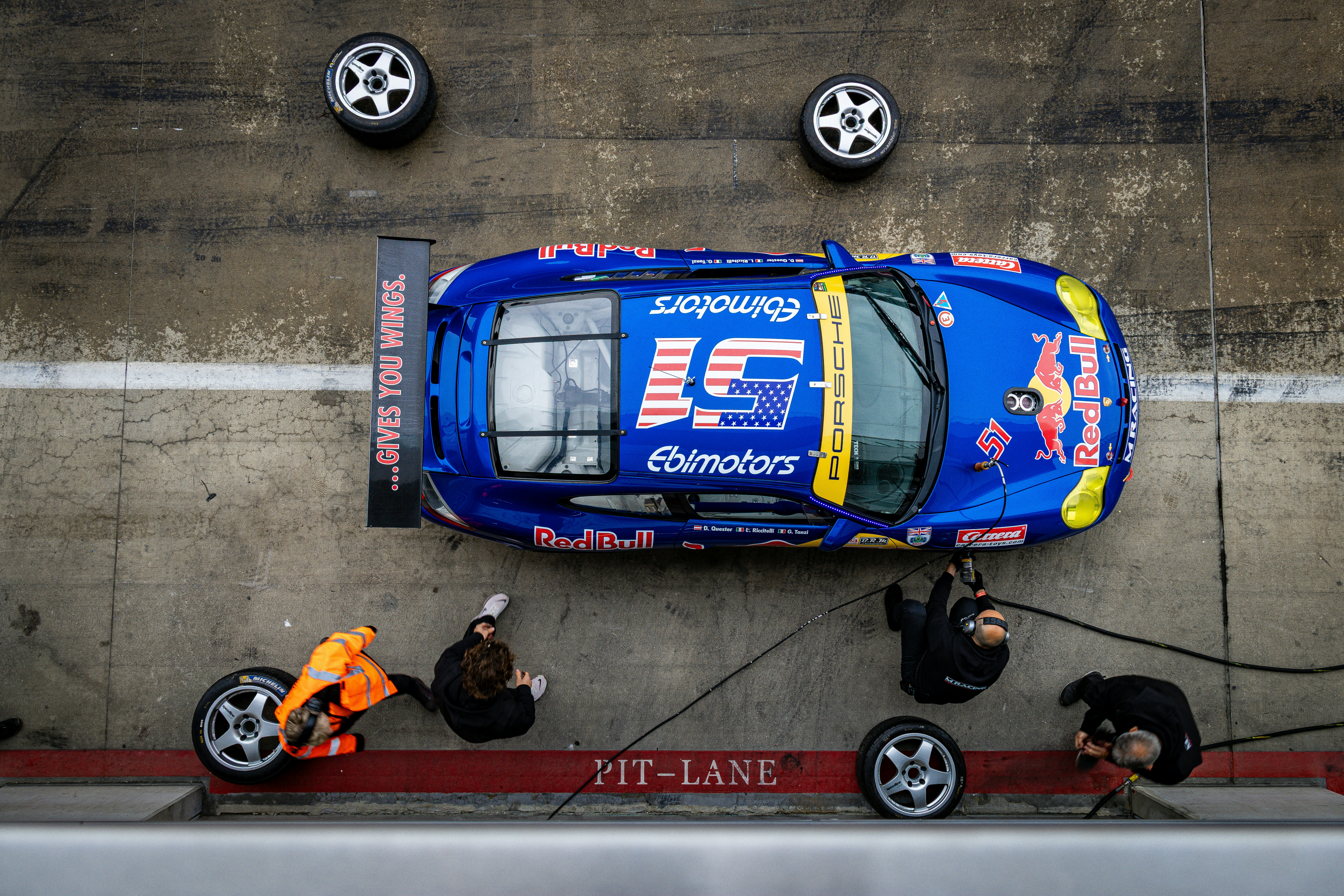 Pit crew changing the tires on a race car.