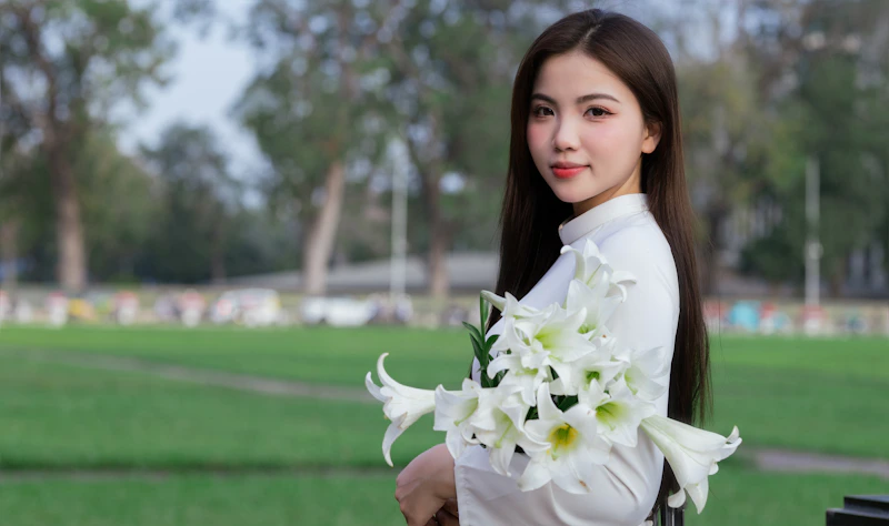 woman posing outdoors with white lilies