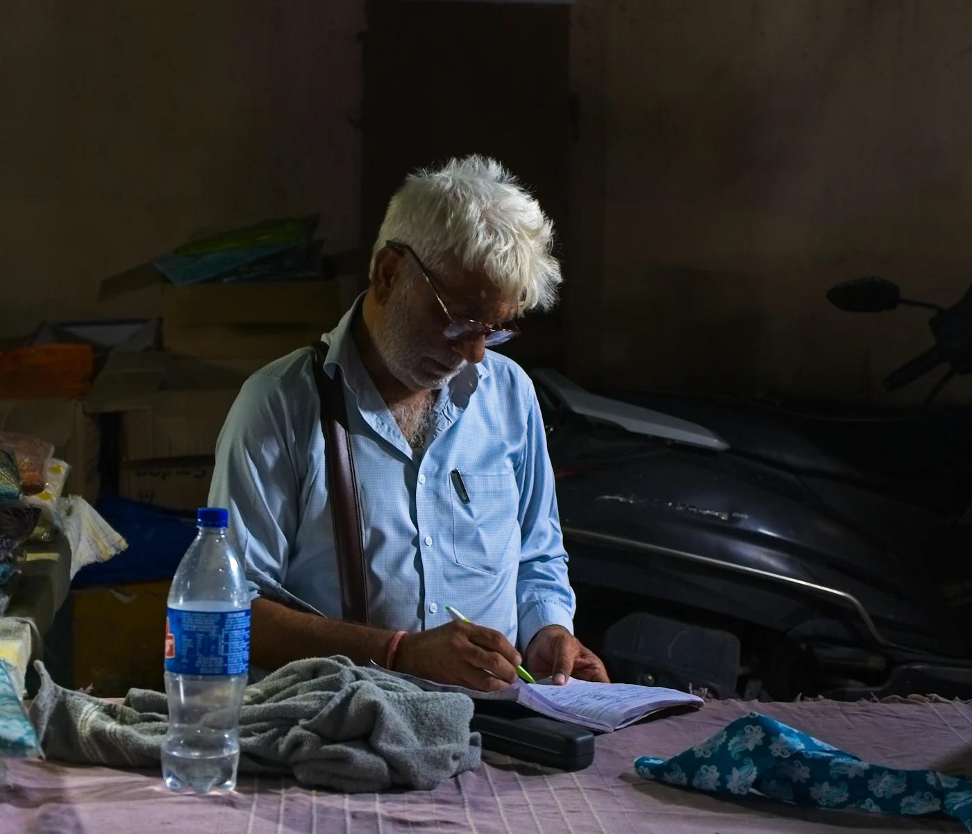 Older man writing notes at a table