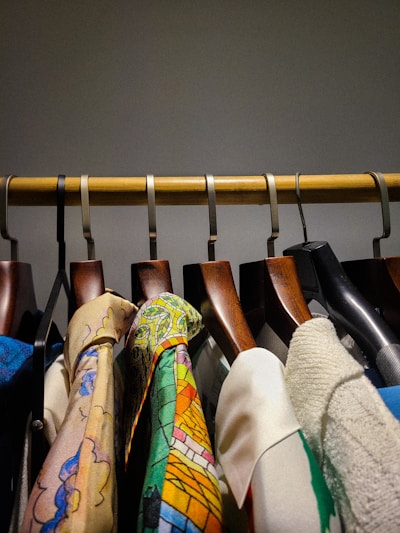 Clothes hang neatly on a wooden rail.