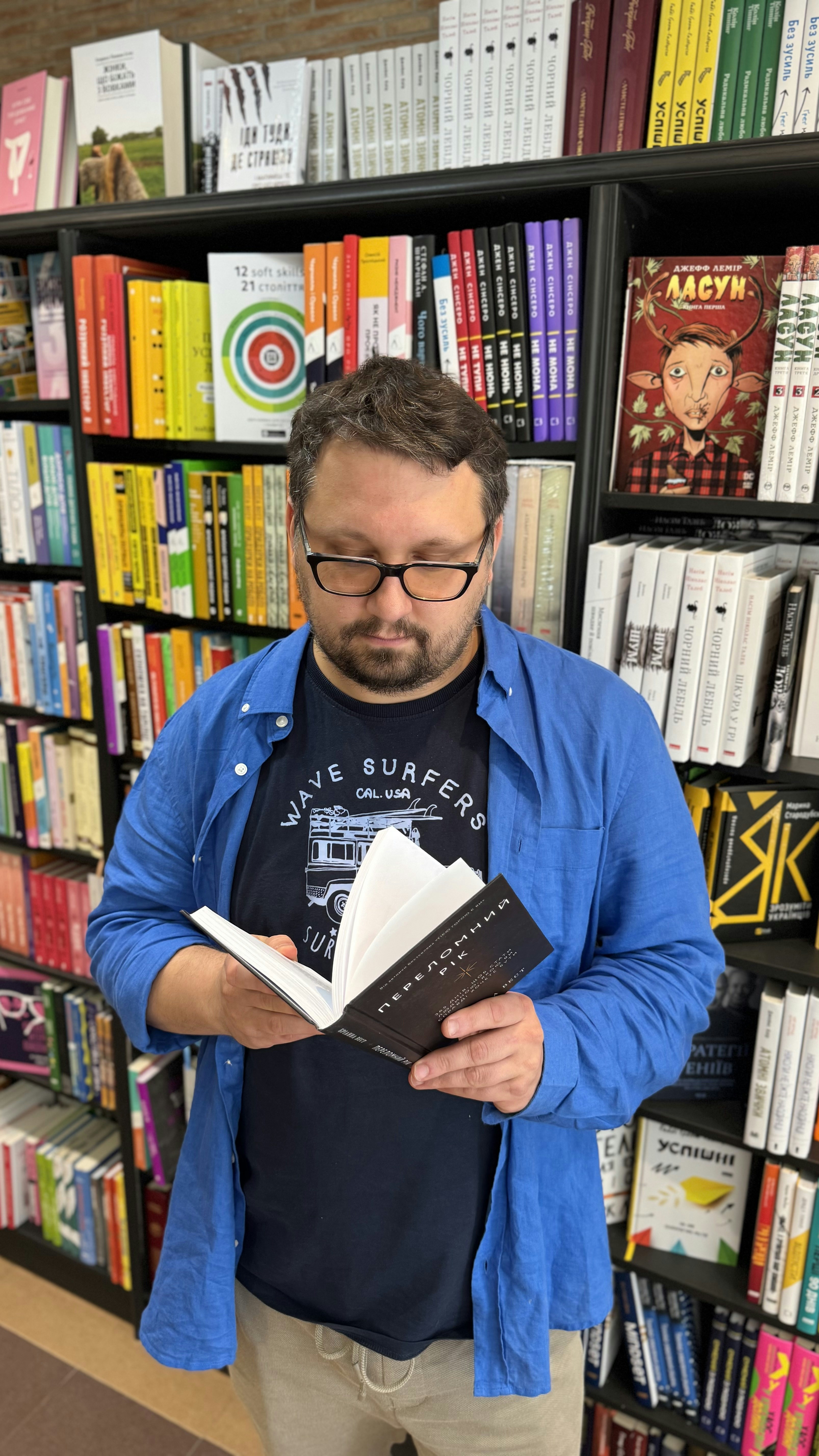 a man reads a book in a bookstore