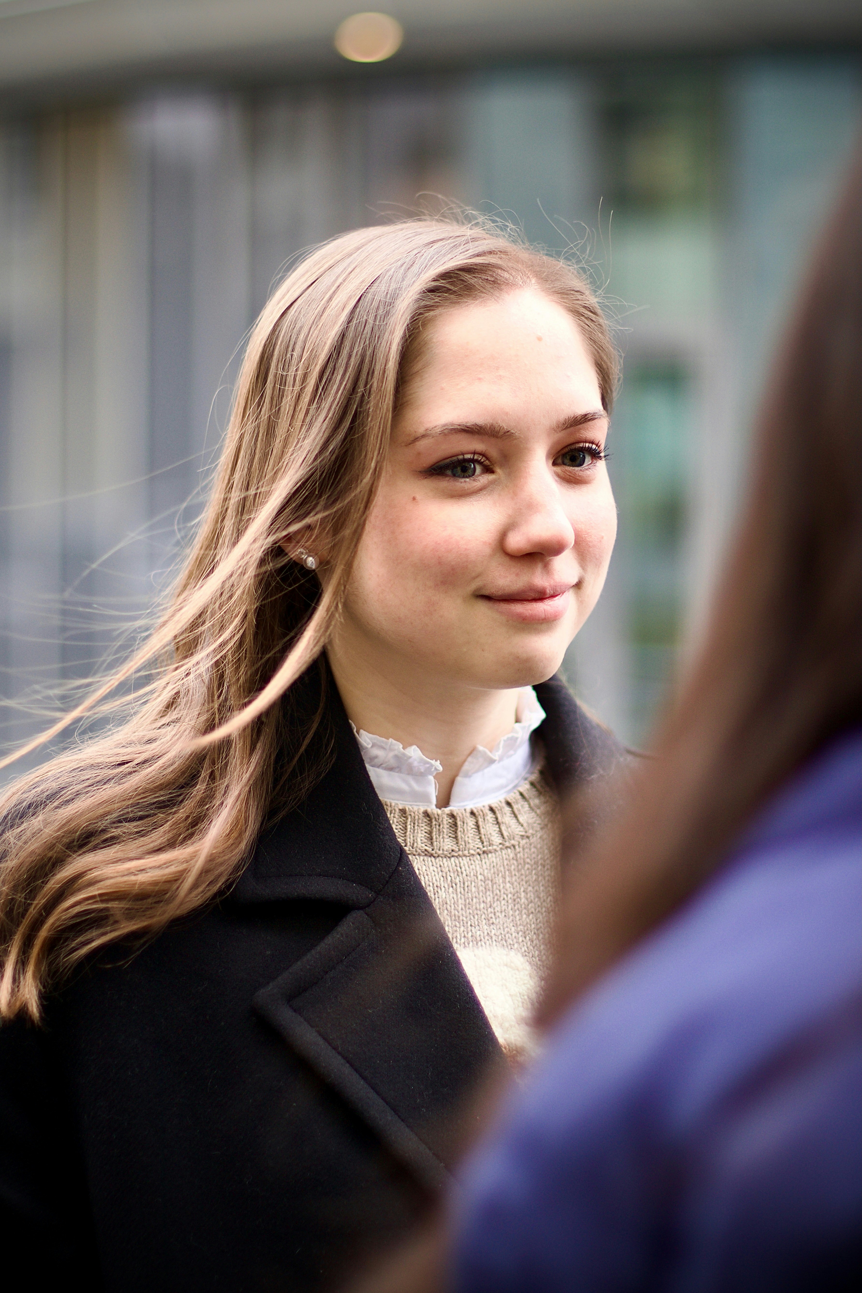 Young woman with long hair smiles.