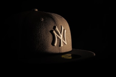 A new york yankees hat against a dark backdrop.