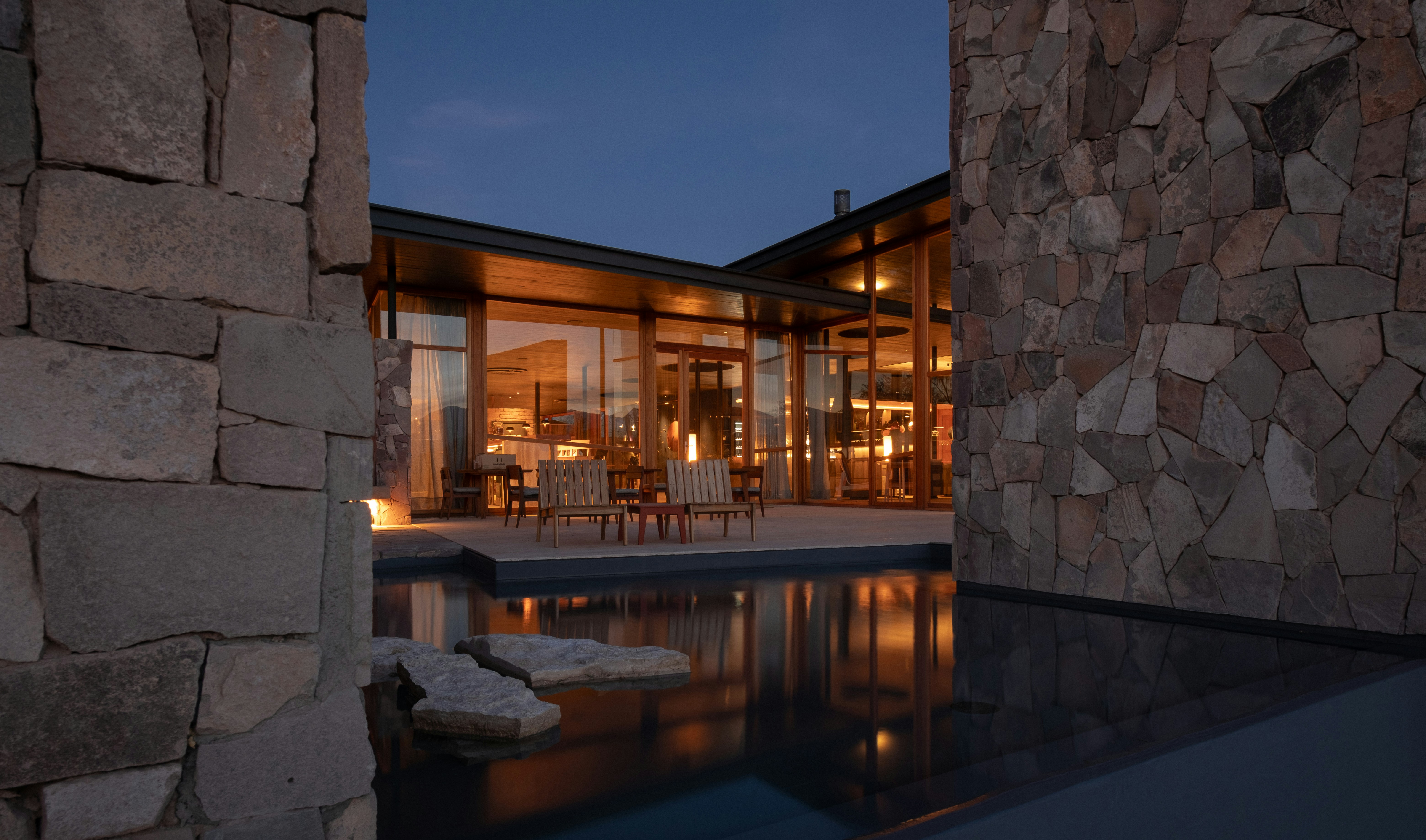 A luxurious house is reflected in the pool.
