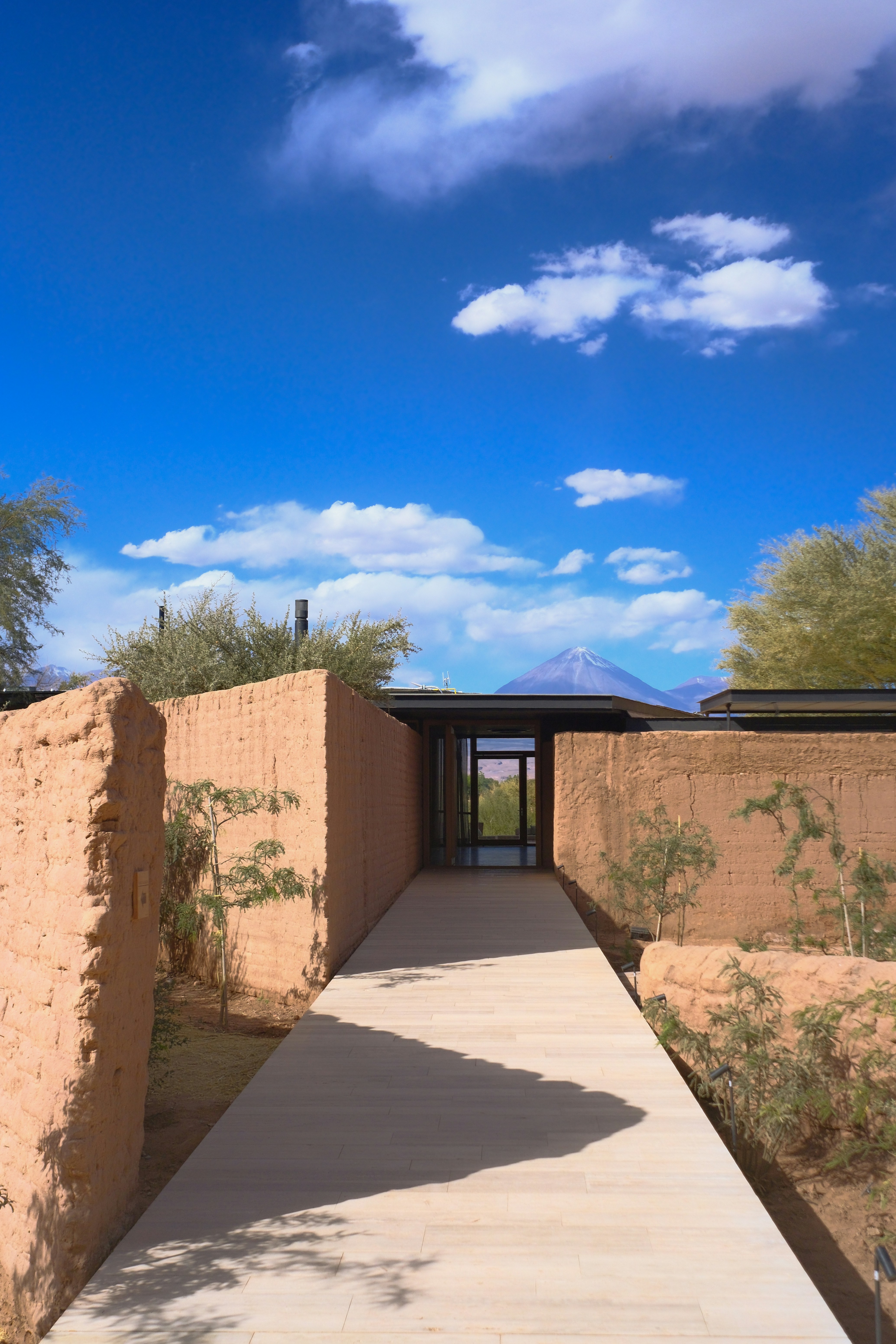 A pathway leads to a door, with a mountain in the distance.