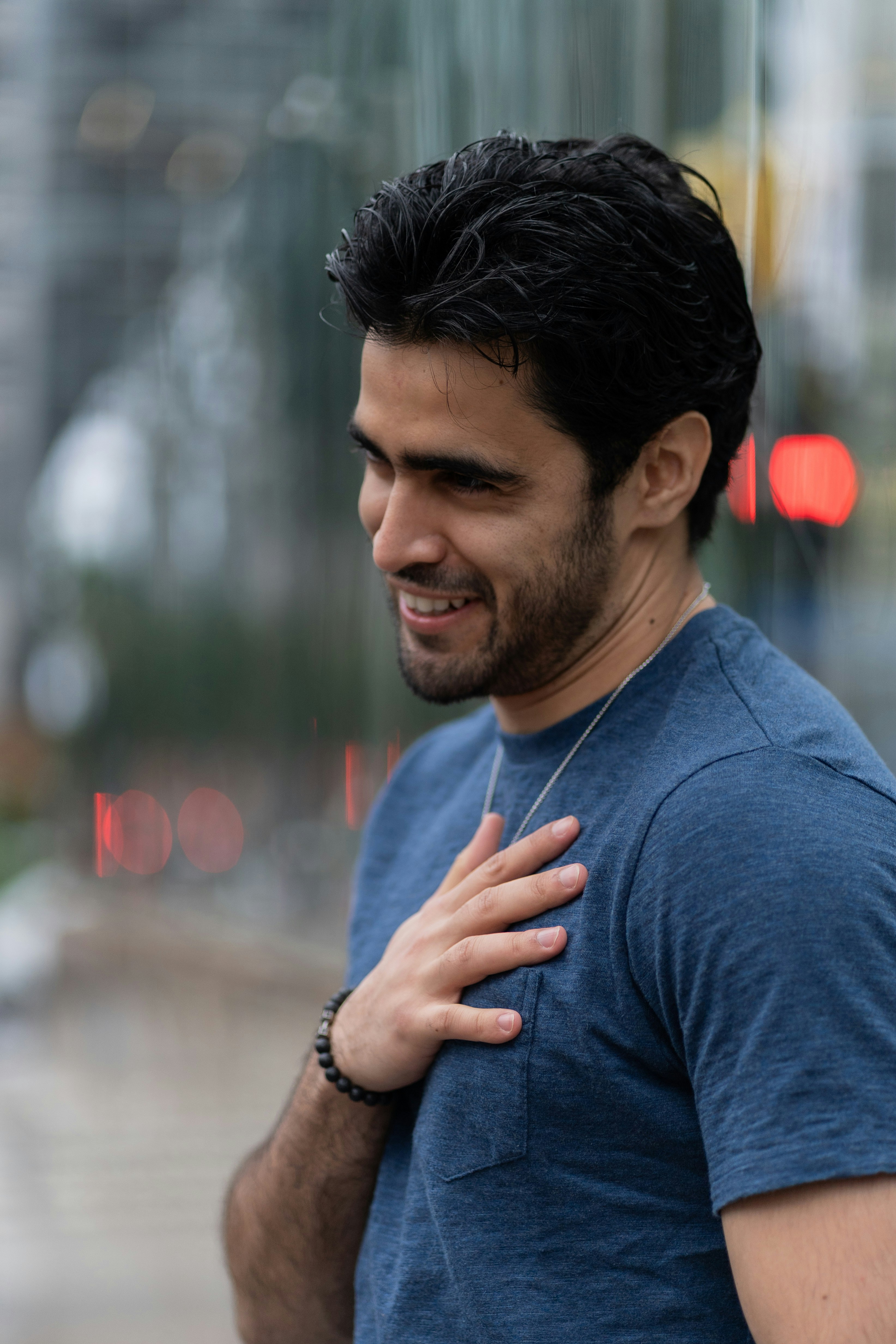 A smiling man puts hand over his heart