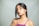 A woman poses looking directly at the camera.