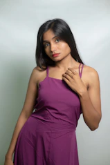 A woman poses in a purple dress