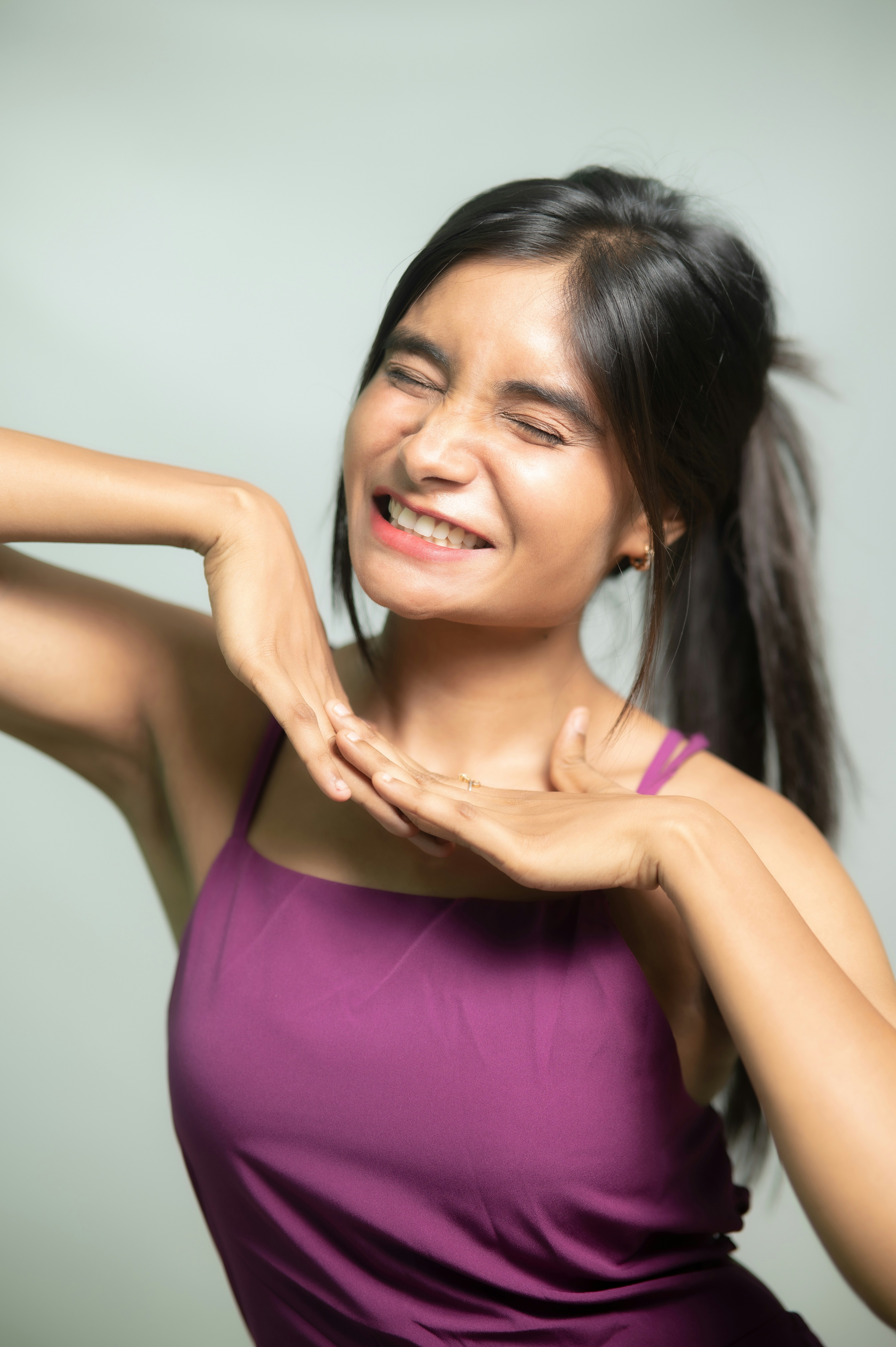 Woman in purple tank top makes an expressive pose.