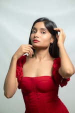 A young woman poses in a red dress.