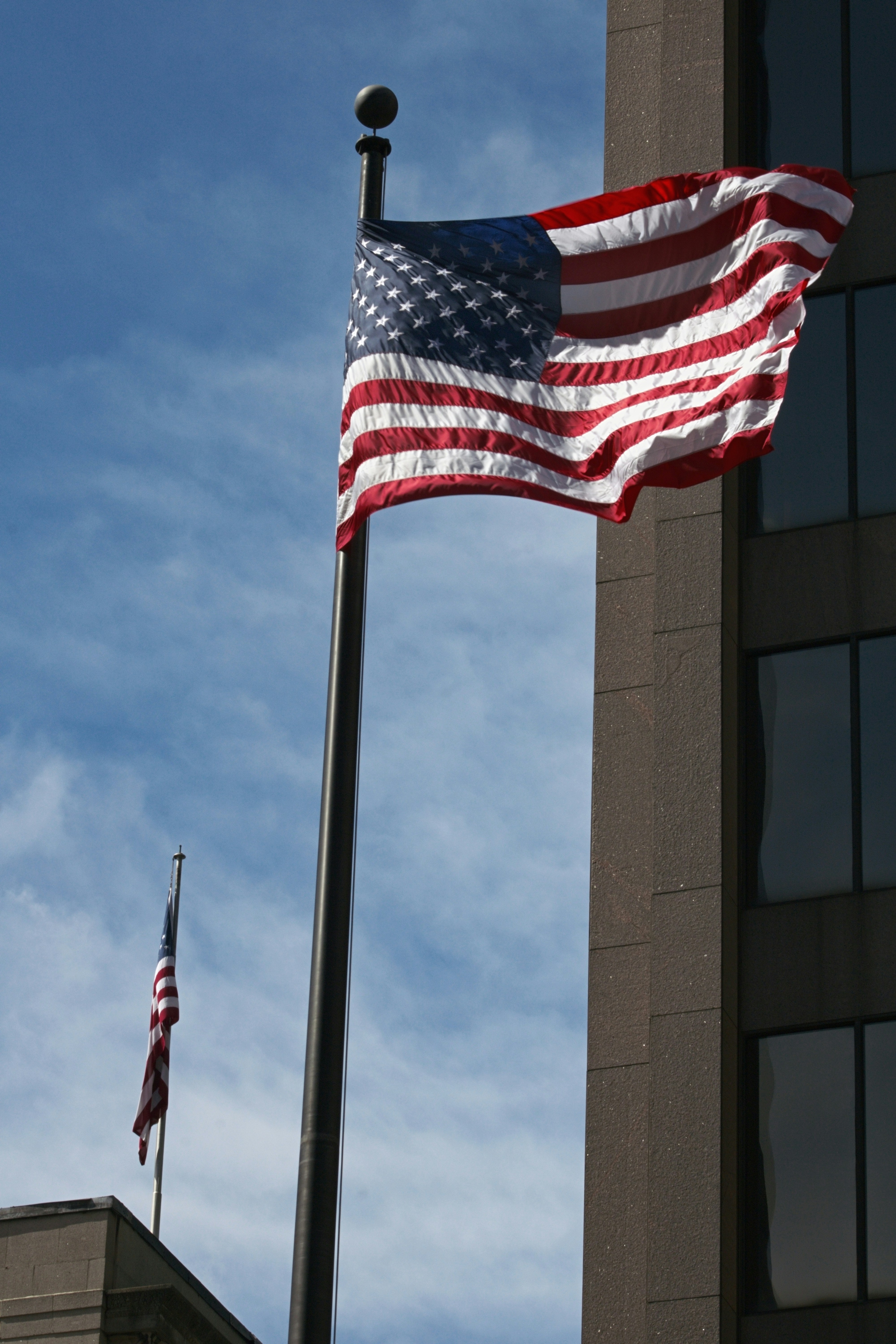 American flags fly against a blue sky.