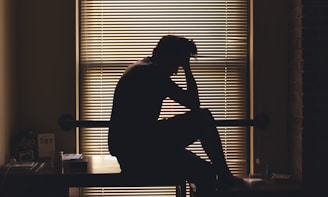 A silhouetted person appears worried and alone.