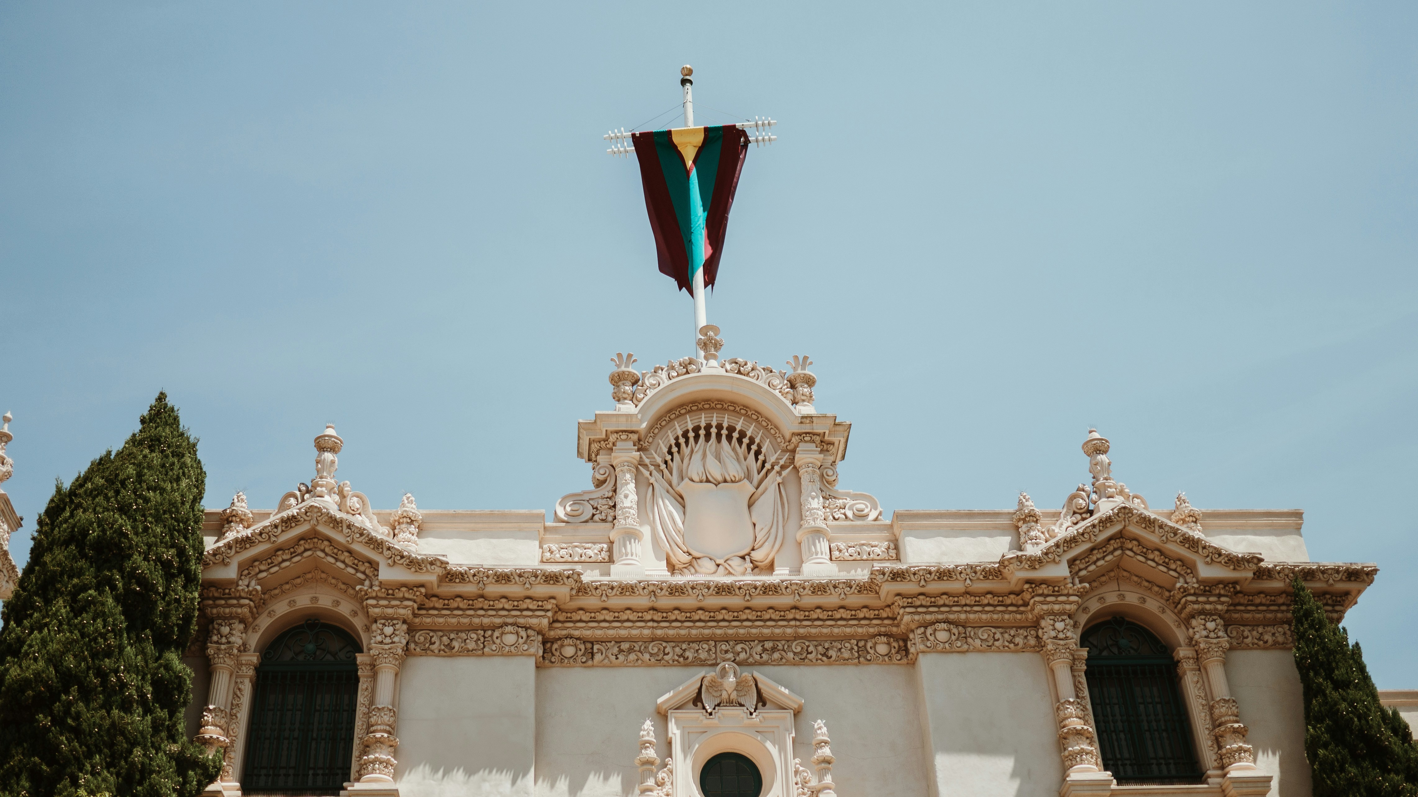 A flag flies over an ornate building.