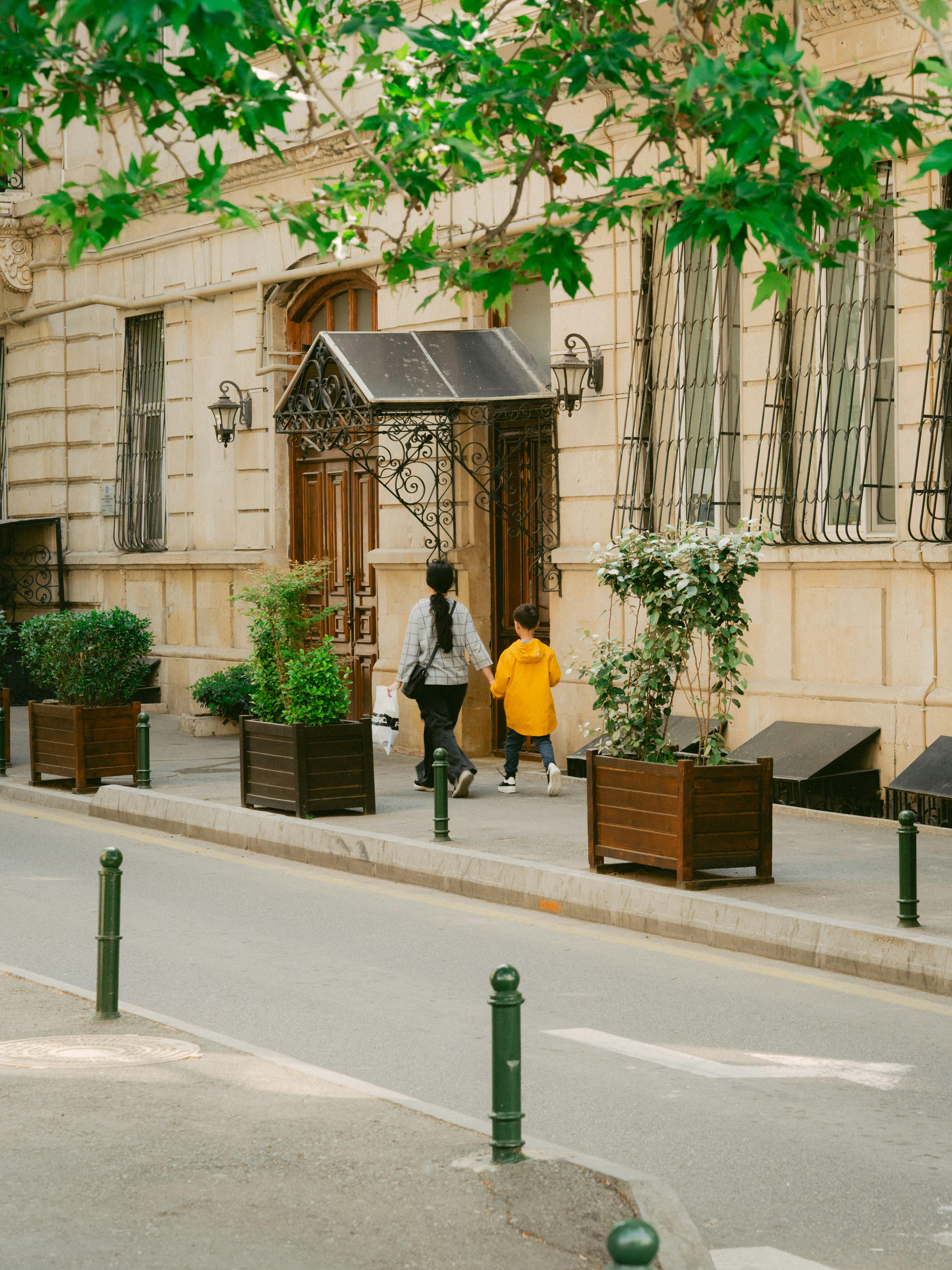 A woman and child walk down a scenic street.