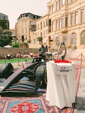 Formula 1 car and trophy displayed outdoors.