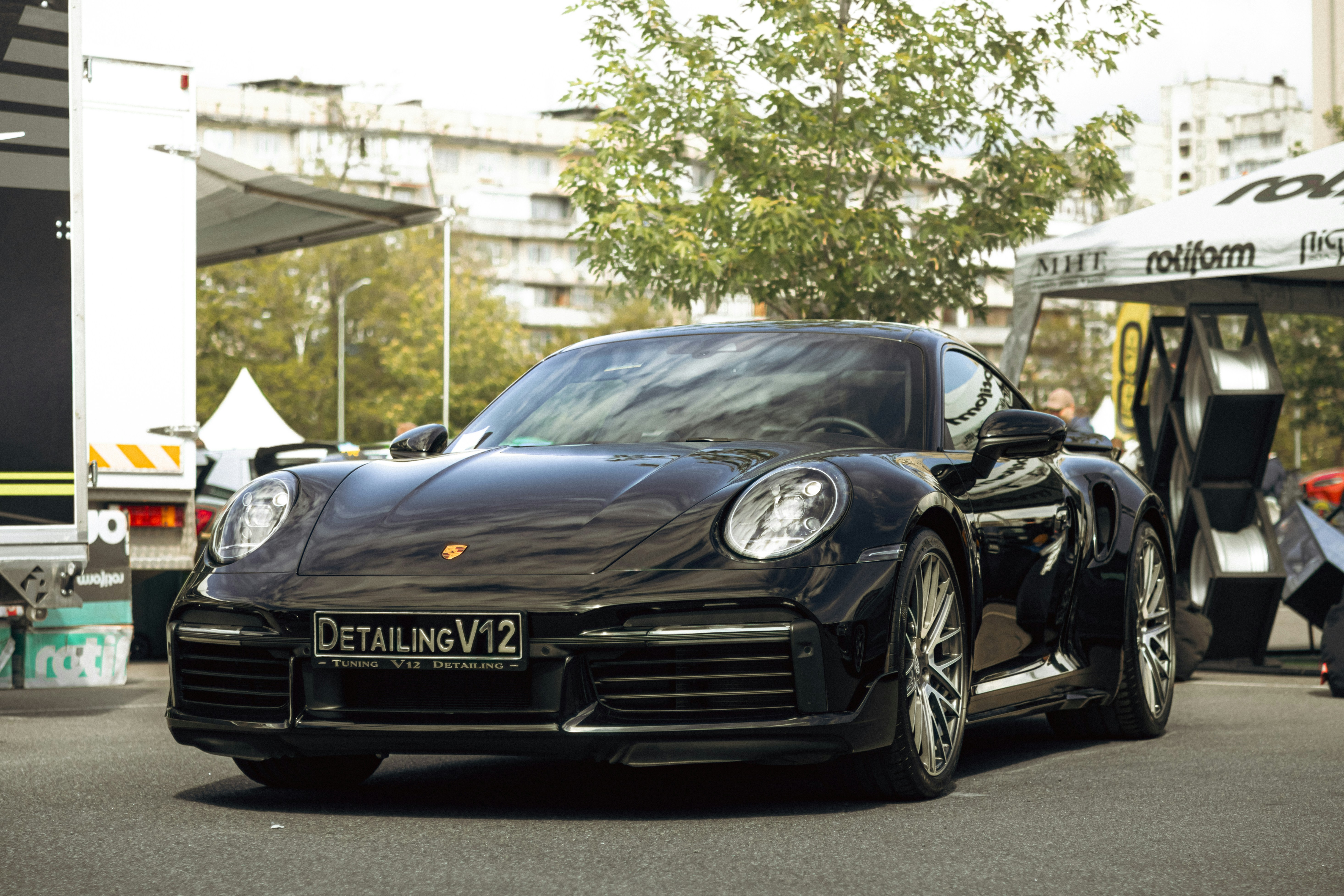 A sleek black porsche is parked outdoors.