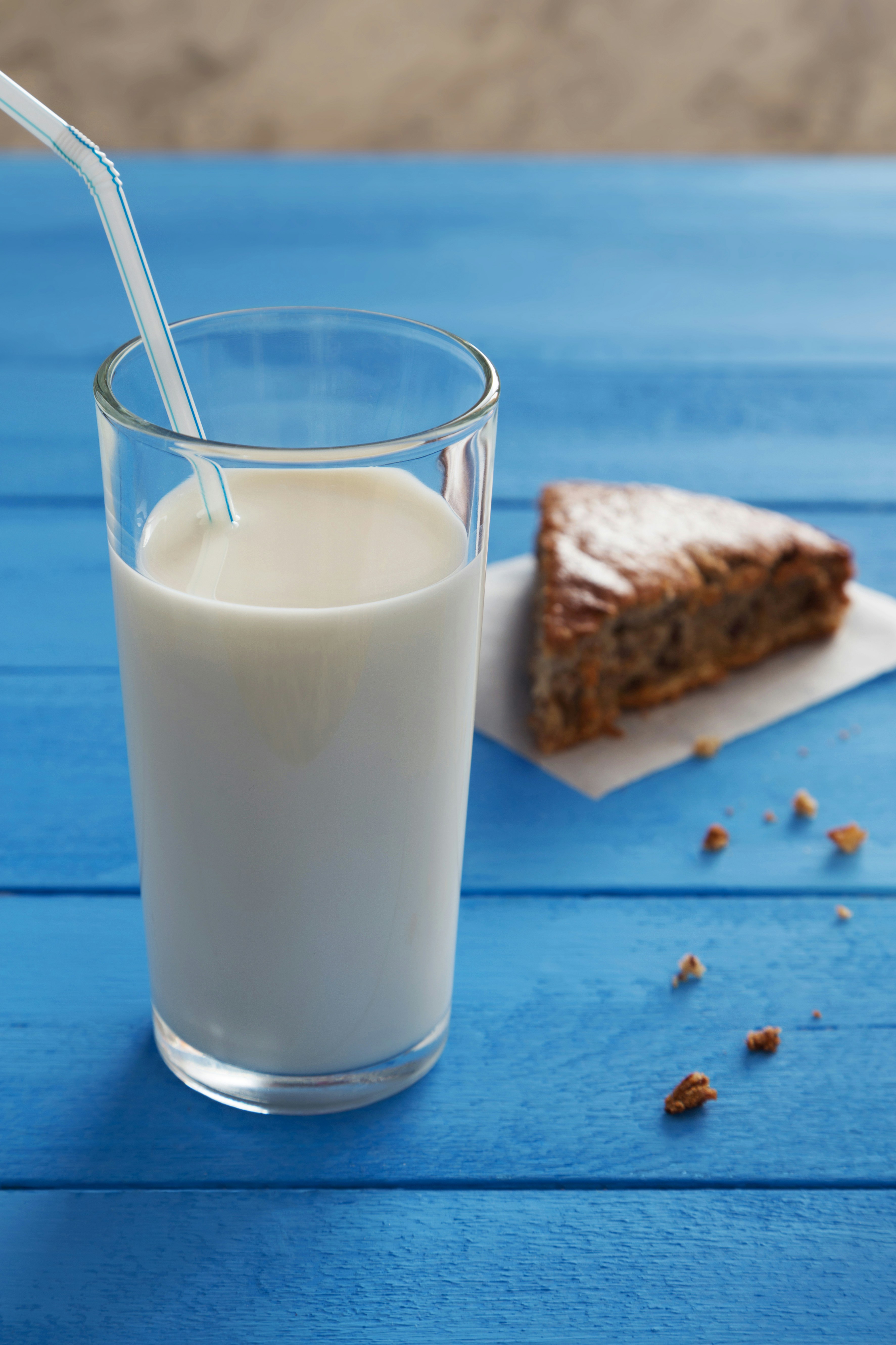 Milk and cake on a bright blue surface.