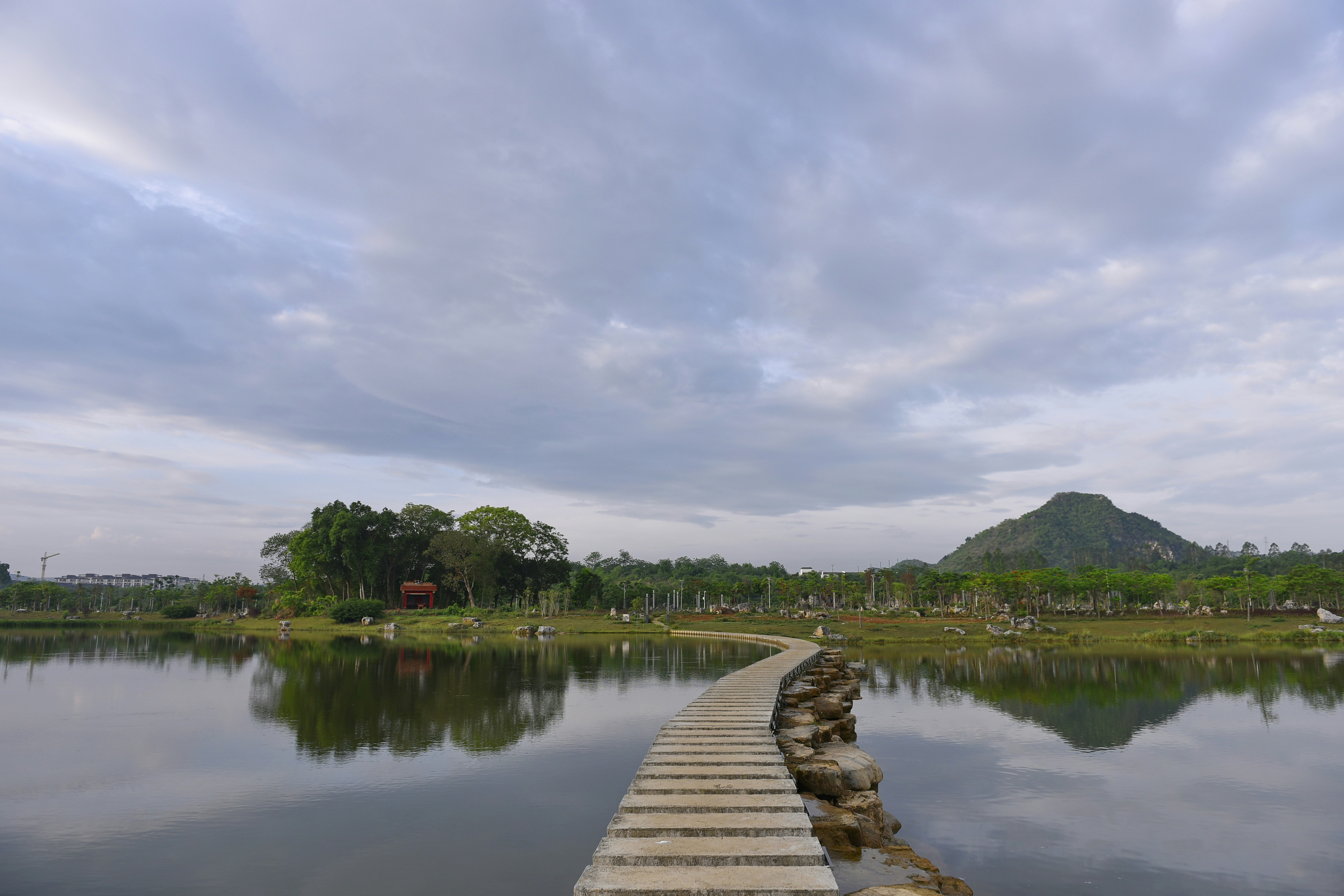 A stone path leads across a still lake.