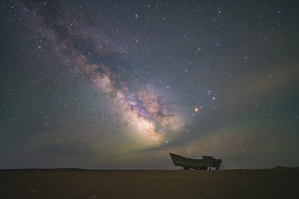 Milky way shines above an old, weathered boat.