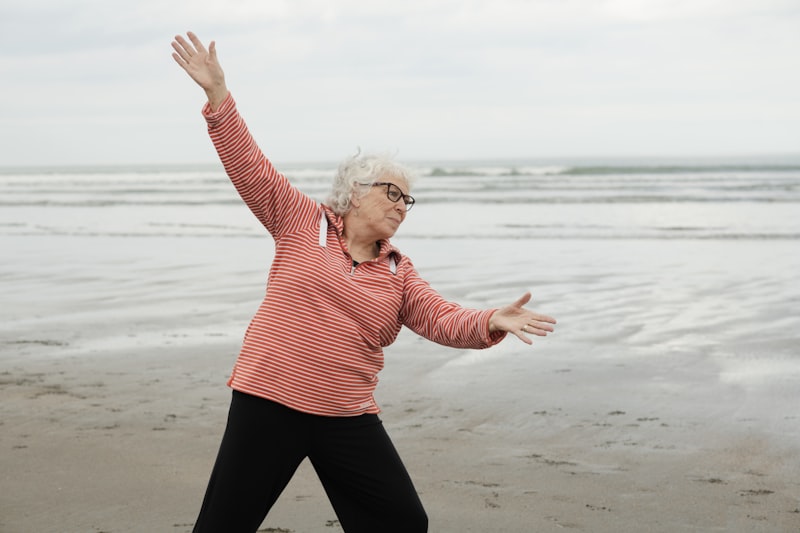 Senior woman exercising outdoors with outstretched arms for shoulder mobility and range of motion