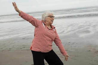 Woman practices tai chi on the beach.