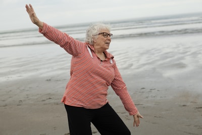 Woman practices tai chi on the beach.