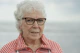 An elderly woman smiles at the camera.