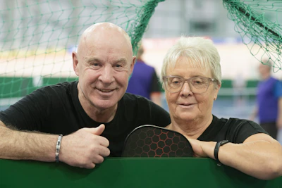 Smiling couple in front of a net.