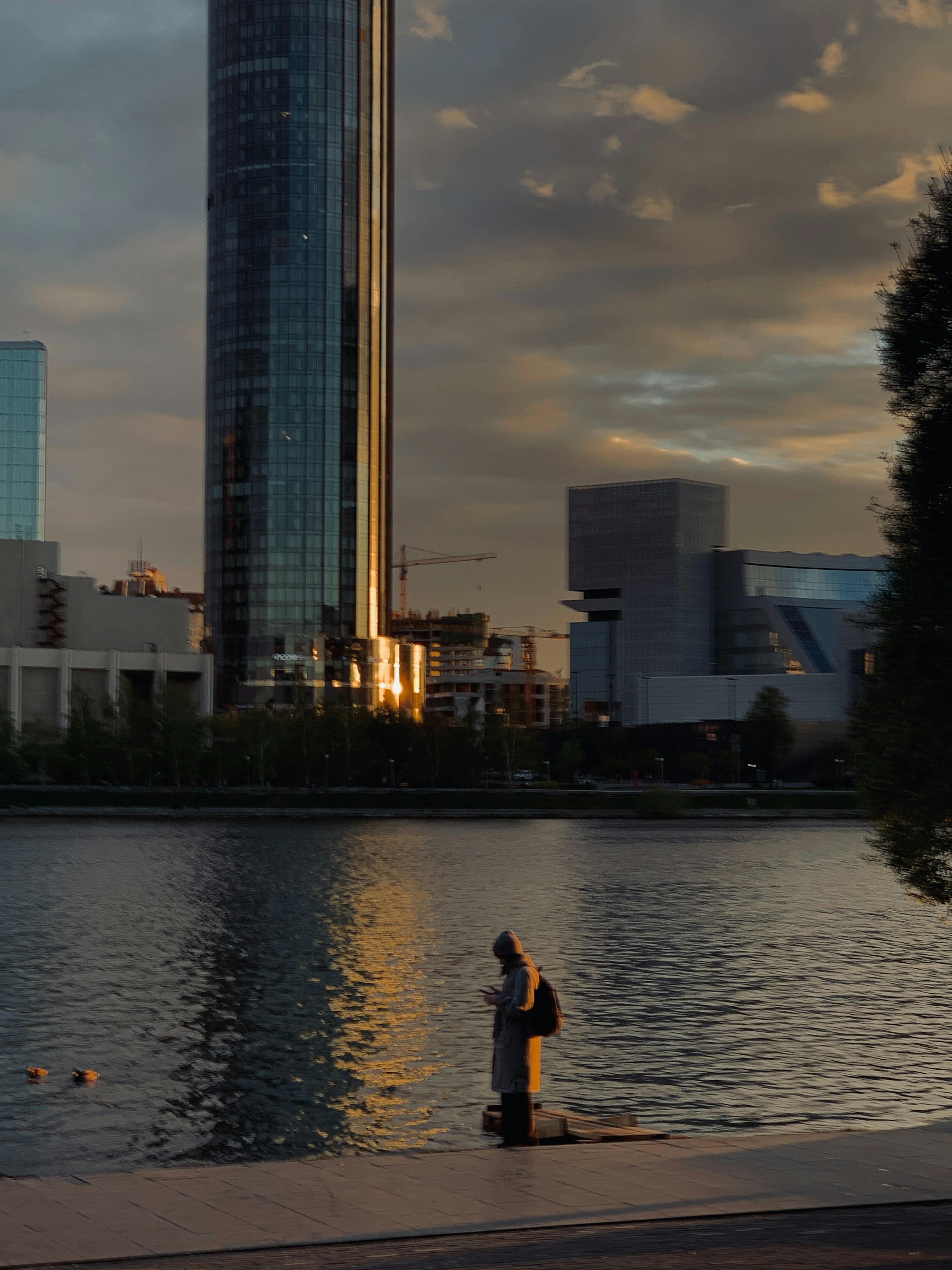 A skyline reflects on a calm body of water.