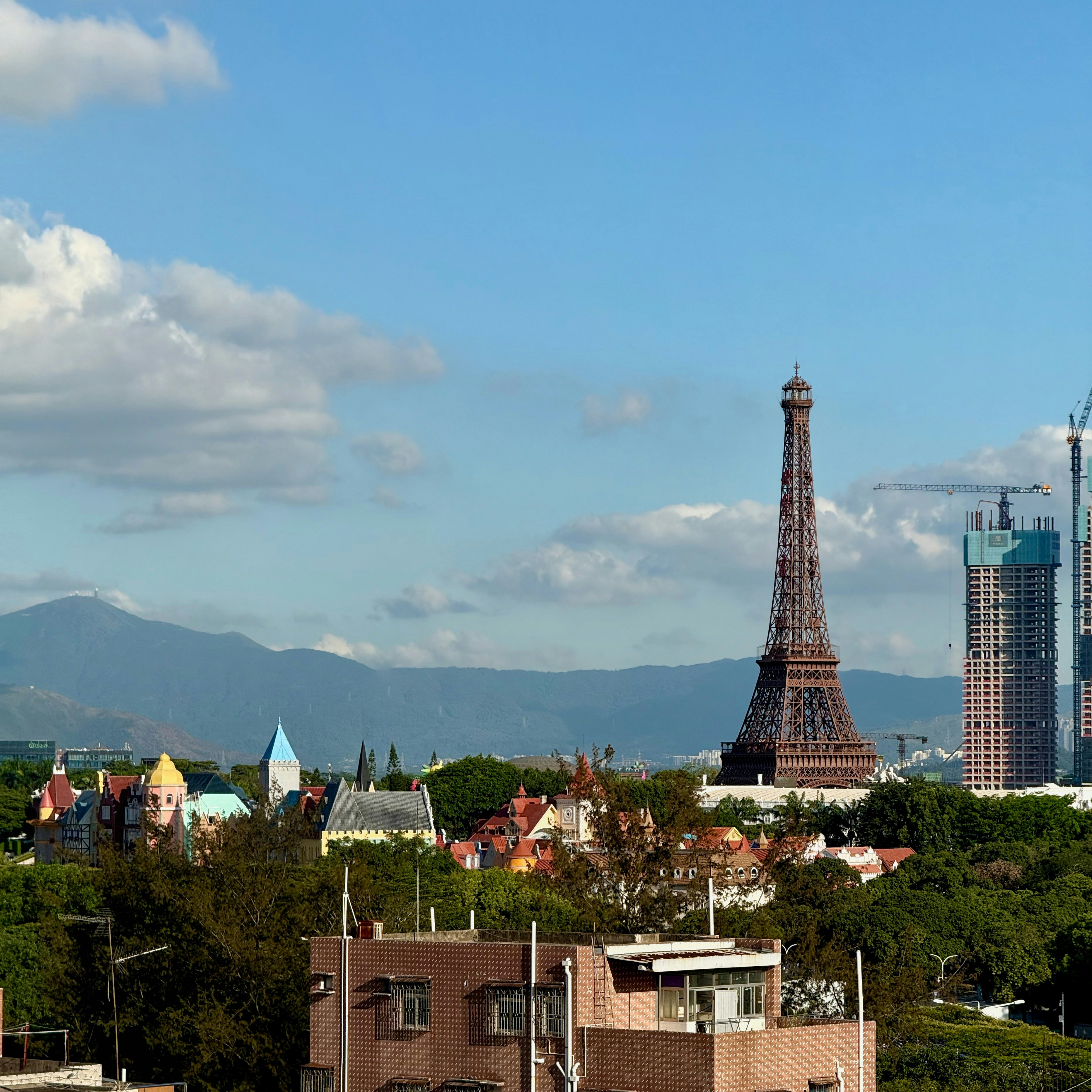A replica eiffel tower stands tall in a cityscape.