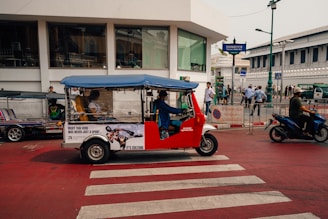 A tuk-tuk travels on a road in thailand.