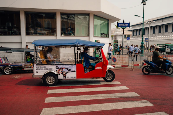 A tuk-tuk travels on a road in thailand.
