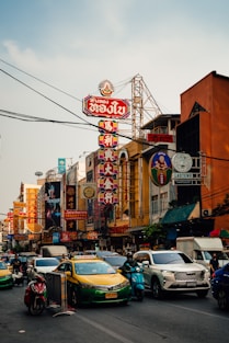Busy chinatown street with bright signs and traffic.