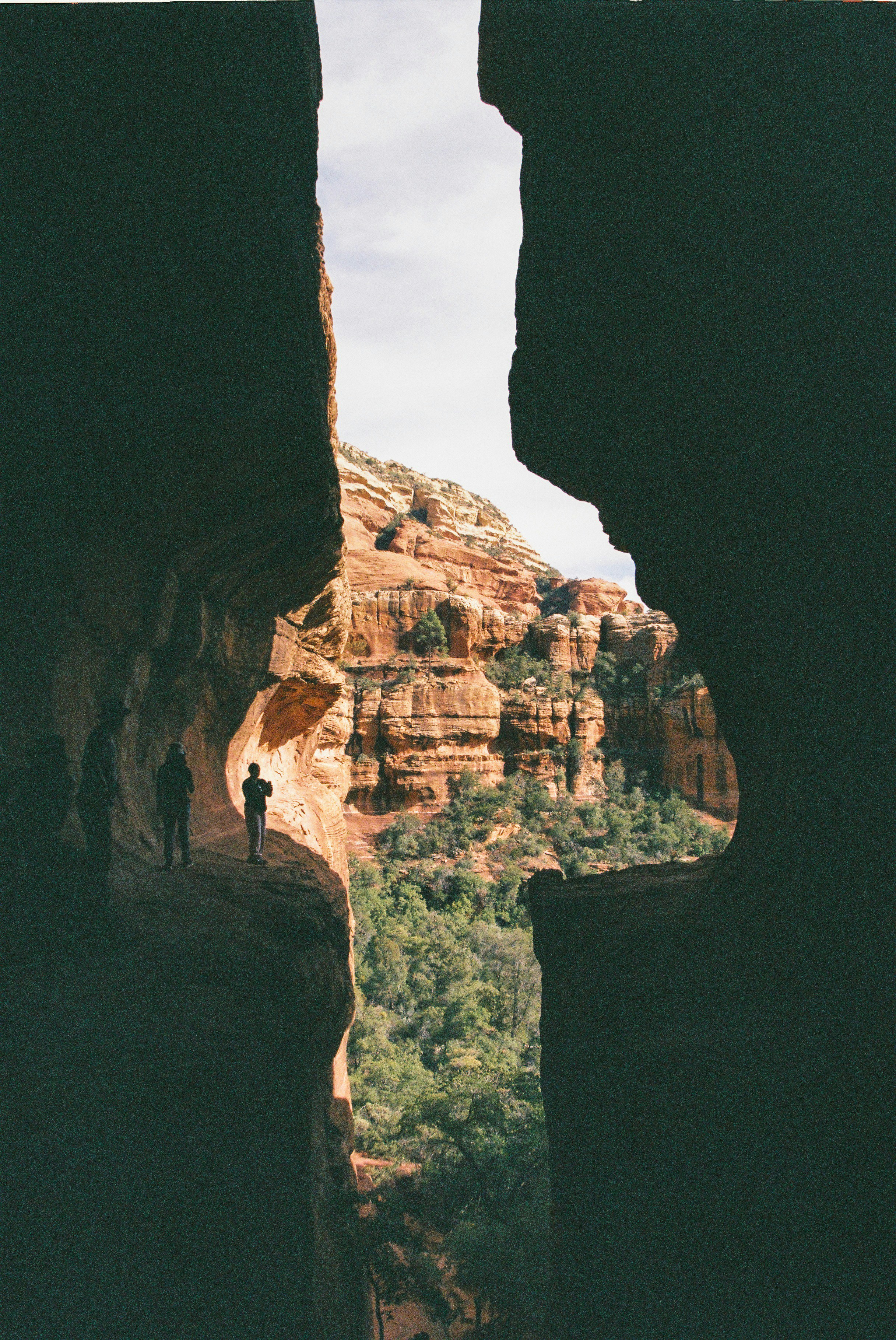 People stand on a cliff overlooking a canyon.