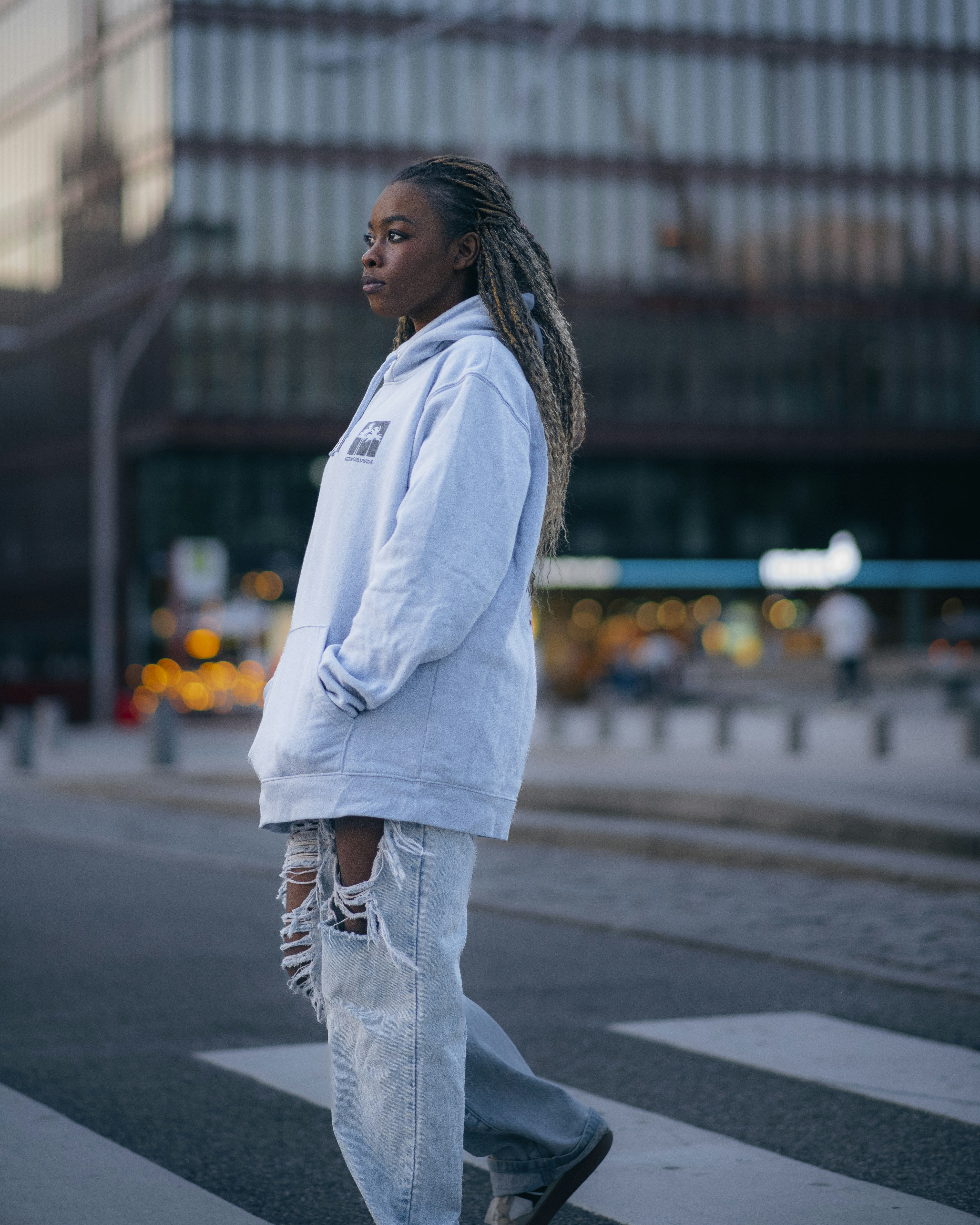 A woman crosses the street in a city setting.