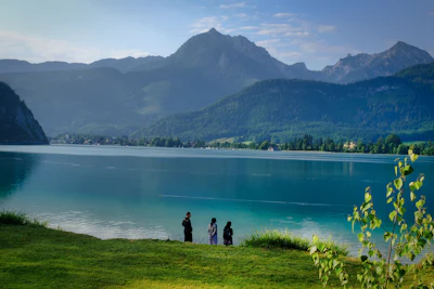 People by a lake overlooking mountains