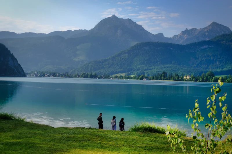 People by a lake overlooking mountains
