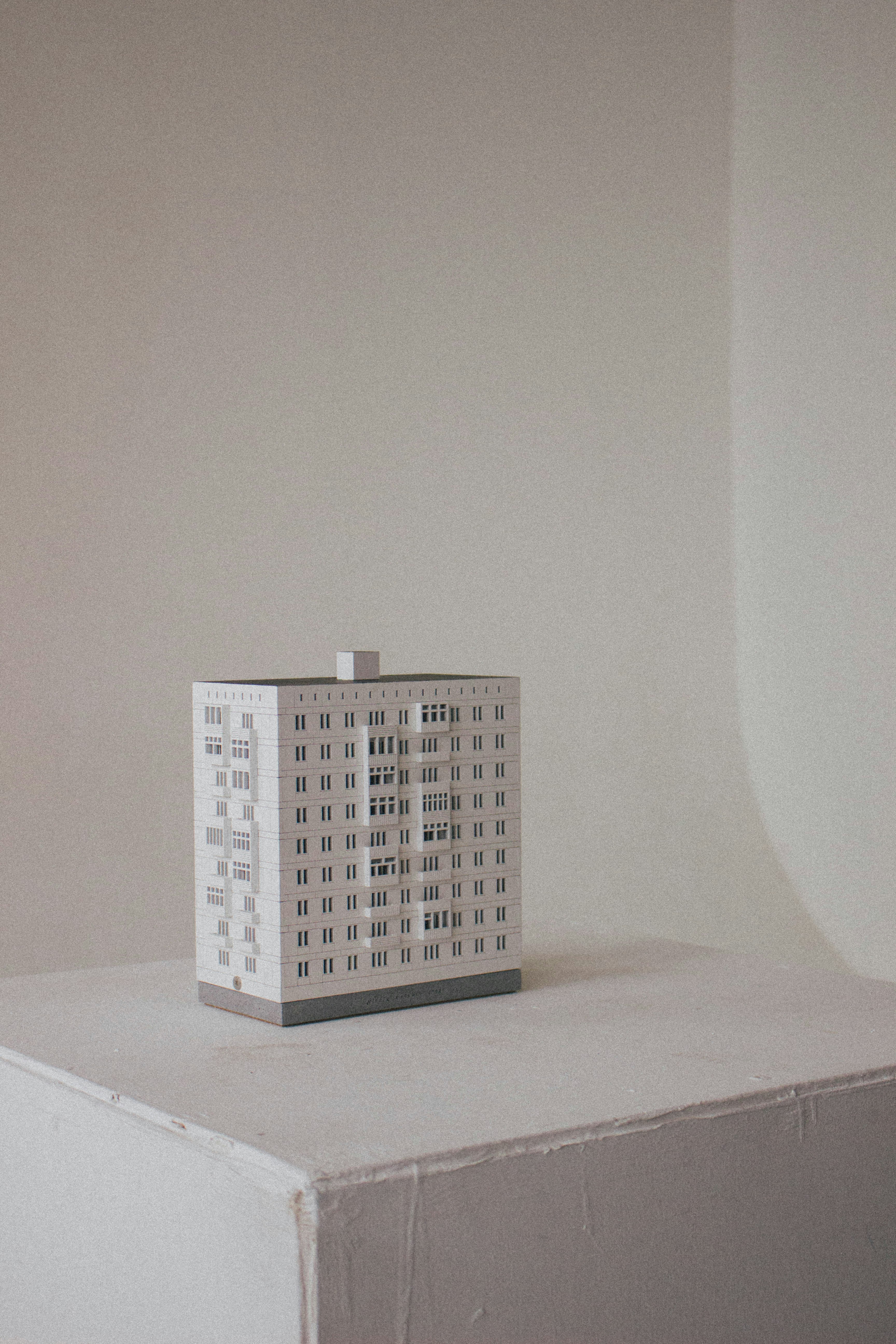 A model of a building sits on a white surface.