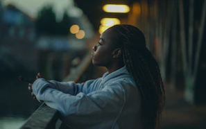 Young woman alone at night looking pensive representing isolation and AI relationships mental health