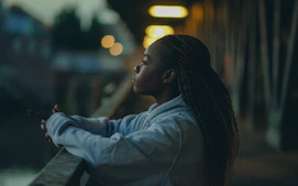 Young woman alone at night looking pensive representing isolation and AI relationships mental health