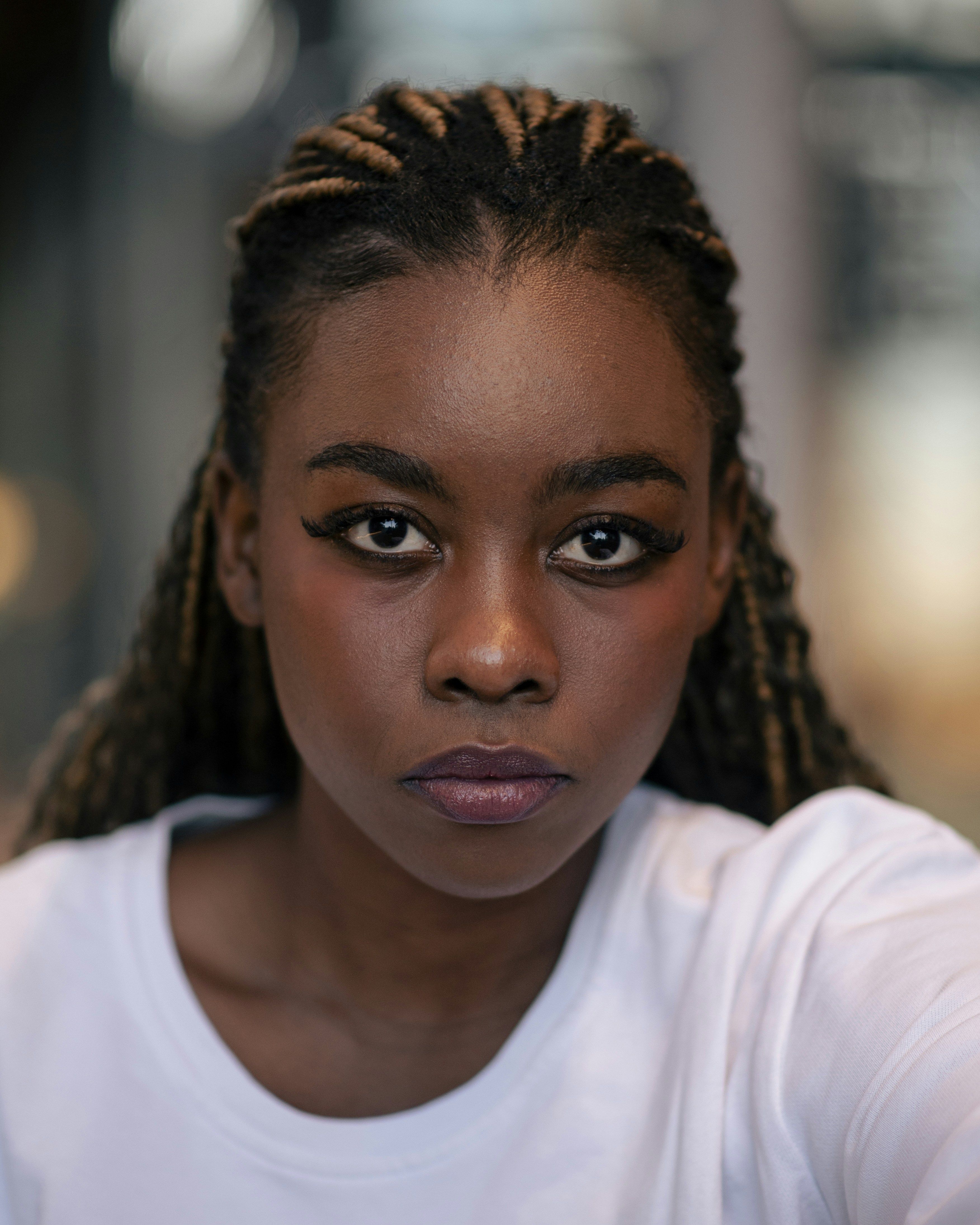 Here is a caption for the image: a beautiful woman with bold makeup stares directly.