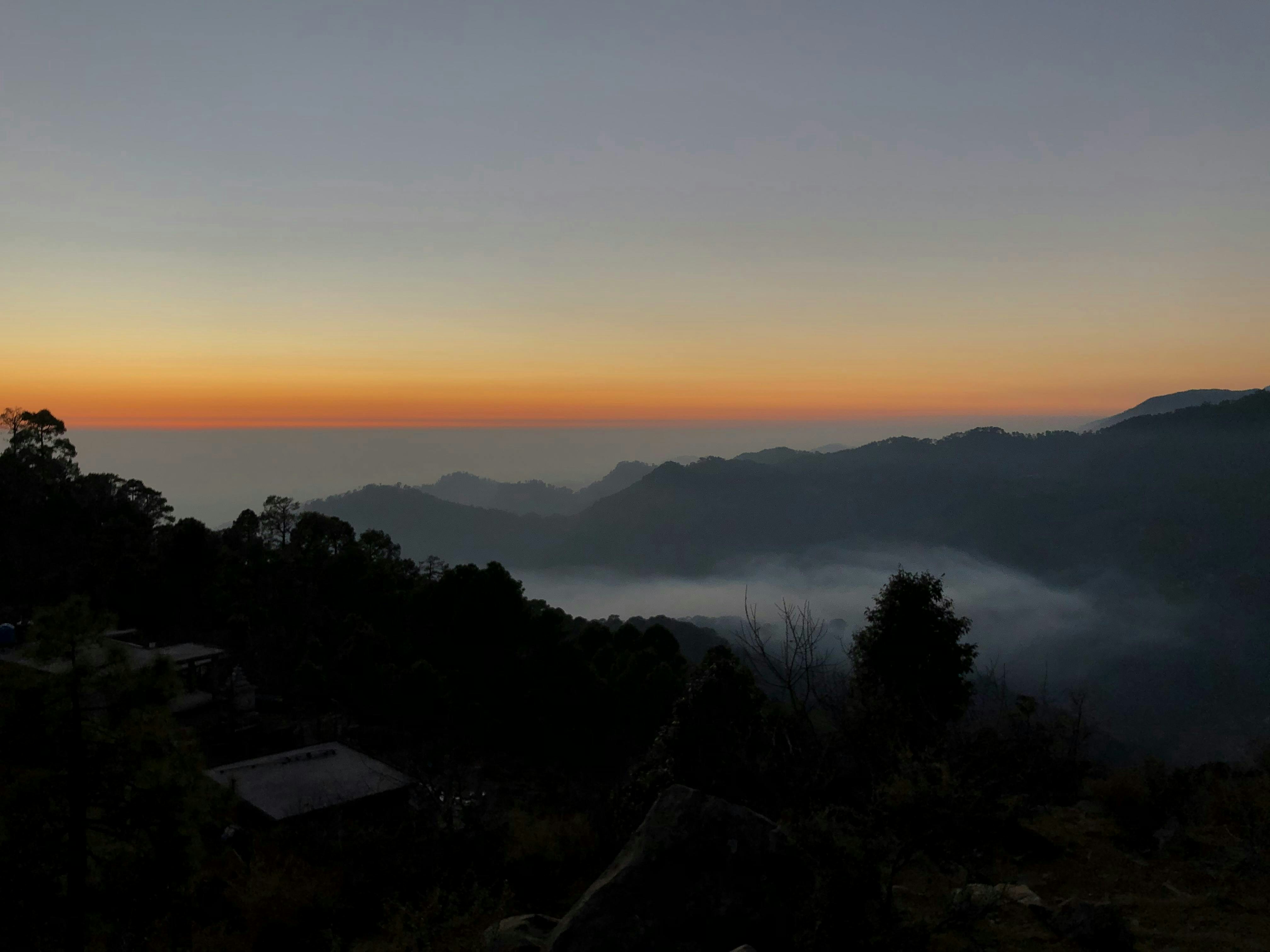 El atardecer pinta el cielo sobre las montañas.