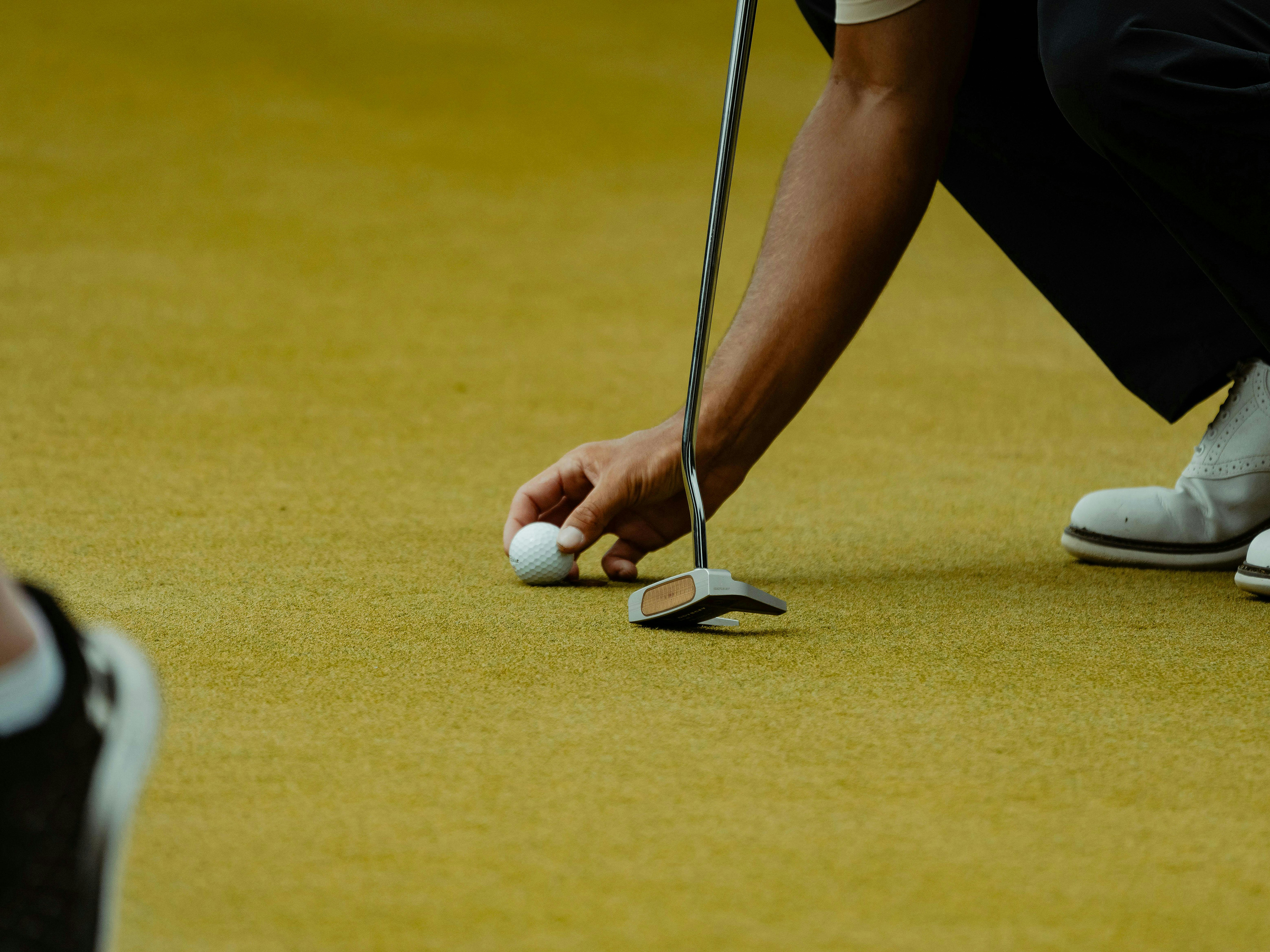 A golfer lines up a putt on the green.