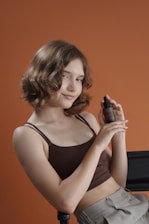 Young woman holds a skincare product bottle.
