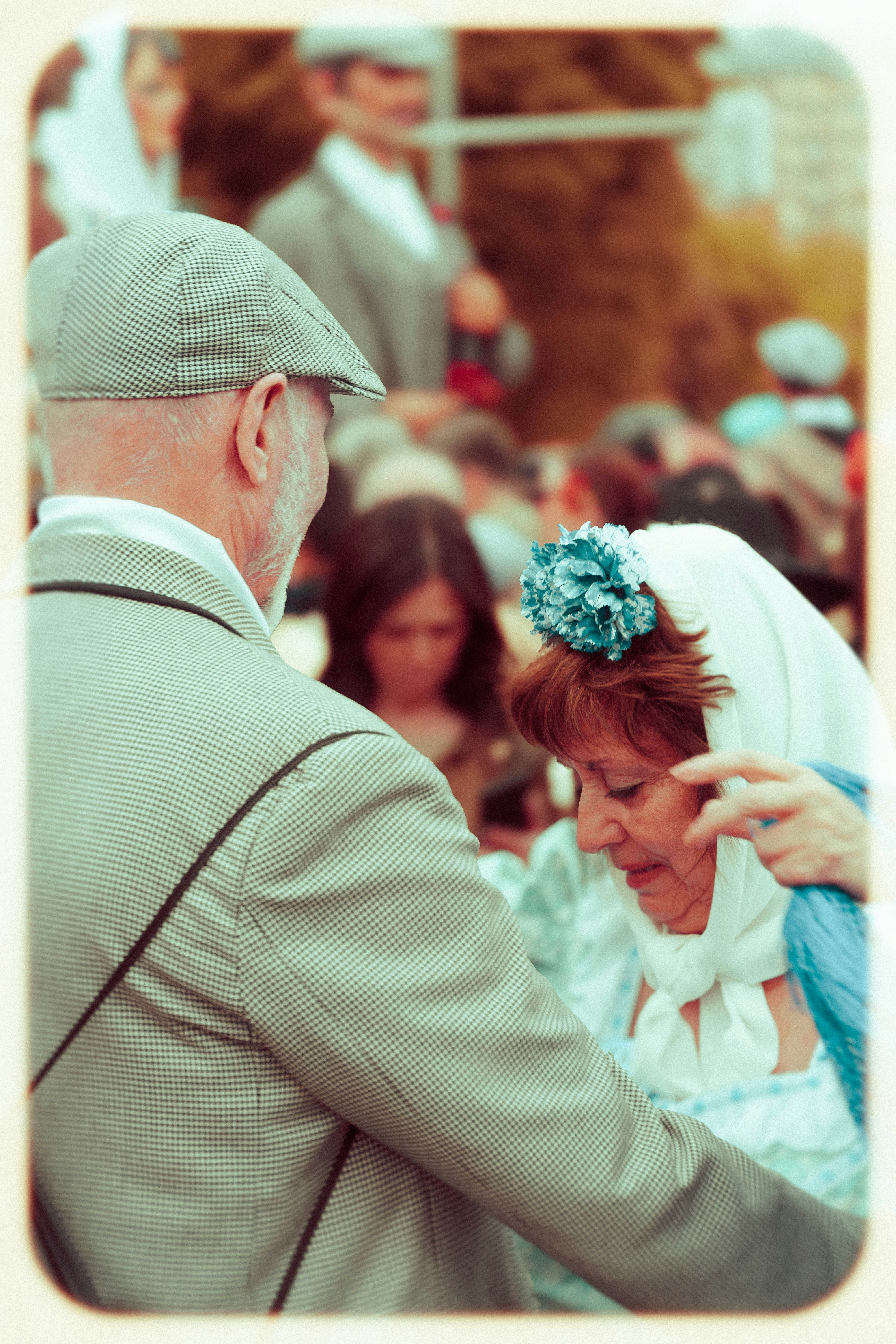 An elderly couple enjoys a festive occasion.