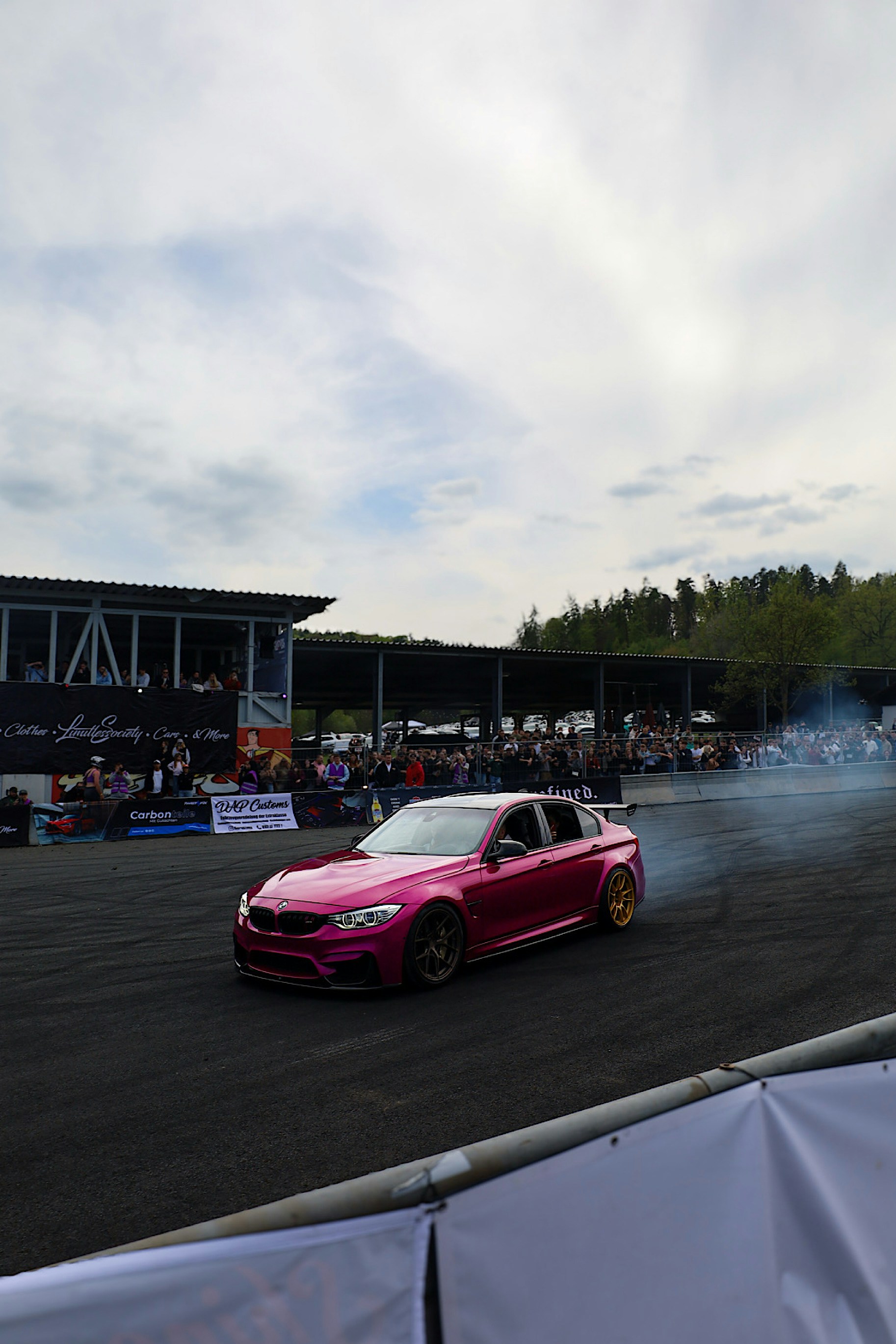 A pink car is drifting on a track.